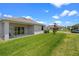 The backyard features a covered patio, well-manicured lawn, and partial view of neighborhood street at 2388 Volunteer Ave, Kissimmee, FL 34744