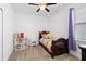 Cozy bedroom with a ceiling fan, window, and a decorative bed with colorful blankets at 2388 Volunteer Ave, Kissimmee, FL 34744