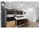 Well-equipped kitchen featuring black cabinetry, a central island with a white countertop, and barstools at 2388 Volunteer Ave, Kissimmee, FL 34744