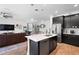 Open-concept kitchen with stainless steel appliances and sleek black cabinets, seamlessly connected to the living area at 2388 Volunteer Ave, Kissimmee, FL 34744
