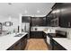 Modern kitchen with stainless steel appliances, white countertops, and sleek black cabinets at 2388 Volunteer Ave, Kissimmee, FL 34744
