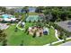 Aerial view of a well-manicured community playground with a tennis court, and lake in the background at 2388 Volunteer Ave, Kissimmee, FL 34744