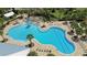 High-angle shot of a resort-style community pool with tanning decks, palm trees, and lounge chairs at 2388 Volunteer Ave, Kissimmee, FL 34744