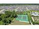 Aerial view of community tennis courts close to the homes, playground, and treed areas at 2388 Volunteer Ave, Kissimmee, FL 34744