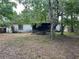 The backyard features mature trees and a partially covered patio at 2558 El Capitan Dr, Sanford, FL 32773