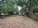 The grassy backyard features some mature trees and a storage shed at 2558 El Capitan Dr, Sanford, FL 32773