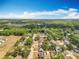 Aerial shot captures a wide residential area with scattered homes and greenery plus distant lake views at 2571 Edmond Cir, Auburndale, FL 33823