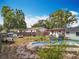 Exterior view of a backyard featuring an empty in-ground pool, wooden fence and some trees at 2571 Edmond Cir, Auburndale, FL 33823