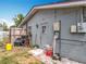 Side view of a home featuring a door with brick accents and some materials piled near the fence at 2571 Edmond Cir, Auburndale, FL 33823