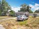 Single story home exterior with solar panels and a silver car parked in the driveway at 2571 Edmond Cir, Auburndale, FL 33823