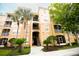 Condo building with lush landscaping, palm trees, and a well-maintained facade at 2788 Almaton Loop # 202, Kissimmee, FL 34747