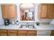 Bright kitchen with stainless steel sink, light wood cabinetry, and an open view to living areas at 2788 Almaton Loop # 202, Kissimmee, FL 34747
