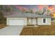 Charming single-story home featuring a gray roof, neutral siding, a two-car garage, and manicured landscaping at 2807 Sw 161St Loop, Ocala, FL 34473