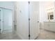 Hallway with tile floors and doors leading to the bathroom and other rooms at 2807 Sw 161St Loop, Ocala, FL 34473