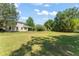 Expansive backyard with mature trees, lush lawn, and a view of the home's exterior, perfect for outdoor living at 2827 Park Meadow Dr, Apopka, FL 32703