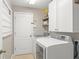Laundry room featuring modern washer and dryer, white cabinets and access door at 2827 Park Meadow Dr, Apopka, FL 32703