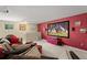 Theater room with large screen, comfortable seating, and red accent wall at 2827 Park Meadow Dr, Apopka, FL 32703