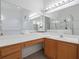 Bright bathroom vanity with large mirror, wooden cabinets and drawers, and a view of the glass shower at 2853 Strand Cir, Oviedo, FL 32765