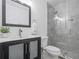 Modern bathroom with glass-enclosed shower, vanity with dark wood cabinets, and decorative mirror at 2853 Strand Cir, Oviedo, FL 32765