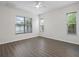 Bright bedroom with hardwood flooring and three windows offering natural light and scenic views at 2853 Strand Cir, Oviedo, FL 32765