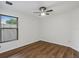 Bedroom featuring wood floors, white walls, a ceiling fan, and natural light from a window at 2853 Strand Cir, Oviedo, FL 32765