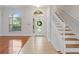 Bright foyer with tile, hardwood floors, arched window and staircase leading to the second floor at 2853 Strand Cir, Oviedo, FL 32765