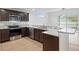 Well-lit kitchen featuring dark wood cabinets, granite countertops, stainless steel appliances and breakfast bar at 2853 Strand Cir, Oviedo, FL 32765
