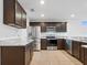 Well-lit kitchen featuring dark wood cabinets, granite countertops, stainless steel appliances and tile floors at 2853 Strand Cir, Oviedo, FL 32765