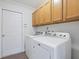 Laundry room with washer and dryer, storage cabinets, and a white door at 2853 Strand Cir, Oviedo, FL 32765