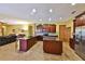 Gourmet kitchen featuring dark wood cabinets, granite countertops, stainless steel appliances, and an island at 2921 Falconhill Dr, Apopka, FL 32712