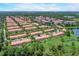 Beautiful aerial view of the townhomes in this lakeside community with lush landscaping and lovely red-tiled roofs at 3001 Red Ginger Rd, Kissimmee, FL 34747