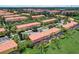 Aerial view of a vibrant community with colorful townhomes, lush landscaping, and serene surroundings at 3001 Red Ginger Rd, Kissimmee, FL 34747
