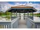 Exterior view of wooden gazebo on a lake with fountain in the background and blue skies at 3001 Red Ginger Rd, Kissimmee, FL 34747