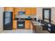 Efficient kitchen layout with black appliances, light wood cabinets, and granite countertops at 3001 Red Ginger Rd, Kissimmee, FL 34747