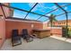 Relax outdoors on this screened in patio with a hot tub, lounge chairs and sunny blue skies at 3001 Red Ginger Rd, Kissimmee, FL 34747