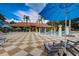 Community pool with a clubhouse, lounge chairs, blue umbrellas, and palm trees at 3001 Red Ginger Rd, Kissimmee, FL 34747