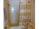 Bathroom with shower and tub combo featuring decorative shower curtain and neutral tile at 3166 S Semoran Blvd # 1007, Orlando, FL 32822