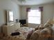 Bright bedroom featuring a large window, dresser, television, and soft, neutral decor at 3166 S Semoran Blvd # 1007, Orlando, FL 32822
