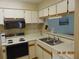 Charming kitchen featuring matching white appliances, bright cabinets, and a double sink at 3166 S Semoran Blvd # 1007, Orlando, FL 32822