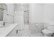 Clean bathroom featuring a white marble-like tiled shower/tub, toilet, and sink with modern fixtures at 348 Famagusta Dr, Davenport, FL 33896