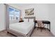 Bright bedroom featuring a queen-sized bed, a desk, and large window with sheer curtains at 348 Famagusta Dr, Davenport, FL 33896