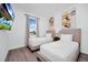 Bright bedroom featuring two twin beds, modern art, and a window with scenic outdoor views at 348 Famagusta Dr, Davenport, FL 33896