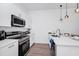 Clean kitchen boasts stainless appliances, sleek white cabinets, modern lighting, and quartz countertops at 348 Famagusta Dr, Davenport, FL 33896