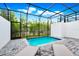 Inviting pool in screened enclosure, featuring stone pavers and comfortable lounge seating, perfect for outdoor relaxation at 348 Famagusta Dr, Davenport, FL 33896