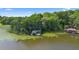 Scenic aerial shot showcases a covered dock amidst a lily pad-filled lake and verdant shoreline at 4107 Gabriella Ln, Winter Park, FL 32792