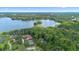 Breathtaking aerial view showcases a serene lake with mature trees and luxurious lakefront estates at 4107 Gabriella Ln, Winter Park, FL 32792