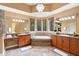 Elegant bathroom featuring a large tub, dual sinks, and plenty of natural light at 4107 Gabriella Ln, Winter Park, FL 32792