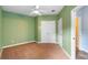 This carpeted bedroom with green walls features a ceiling fan and a large closet at 4107 Gabriella Ln, Winter Park, FL 32792