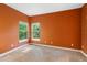 This carpeted bedroom has orange walls and two bright windows at 4107 Gabriella Ln, Winter Park, FL 32792