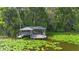 Picturesque lakefront dock featuring a covered boat lift and surrounded by lush lily pads at 4107 Gabriella Ln, Winter Park, FL 32792